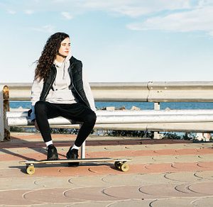 Teenage girl sitting on a bench with stock photo containing female and woman
